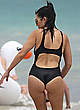 Kourtney Kardashian in black swimsuit on a beach pics