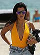Kourtney Kardashian in orange swimsuit on a beach pics