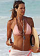 Elle Macpherson in a bikini top on a beach pics
