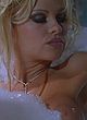 Pamela Anderson lying in bathtub, showing boob pics